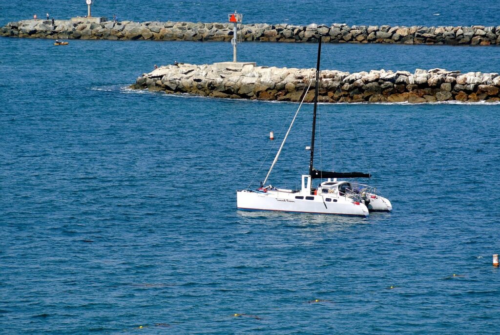 A small sailboat floating across a bay.