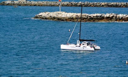 A small sailboat floating across a bay.
